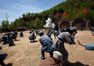 Tourists in military gear take cover during a reenactment of a battle from the Chinese Communist revolution. - Yan’an, Shaanxi