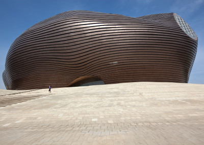 A pedestrian walks by the Ordos Museum in the largely vacant Kangbashi New District. - Ordos, Inner Mongolia