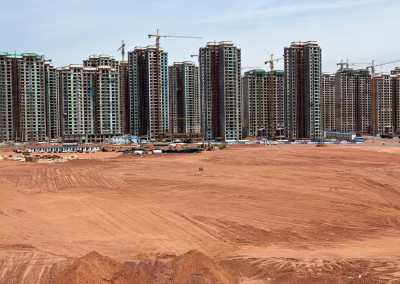 Construction workers walk along megablock developments in the vacant Kangbashi New District. - Ordos, Inner Mongolia