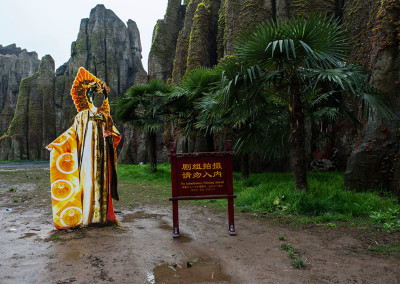 A television character cutout awaits tourists in a fake rock garden on a film set in Hengdian World Studios. - Hengdian, Zhejiang