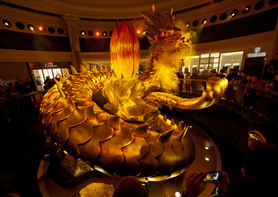 Patrons of Wynn Casino Macau gawk at the "Dragon of Fortune" that rises 28 feet out of the floor and symbolizes vitality, good fortune, and well-being. - Macau