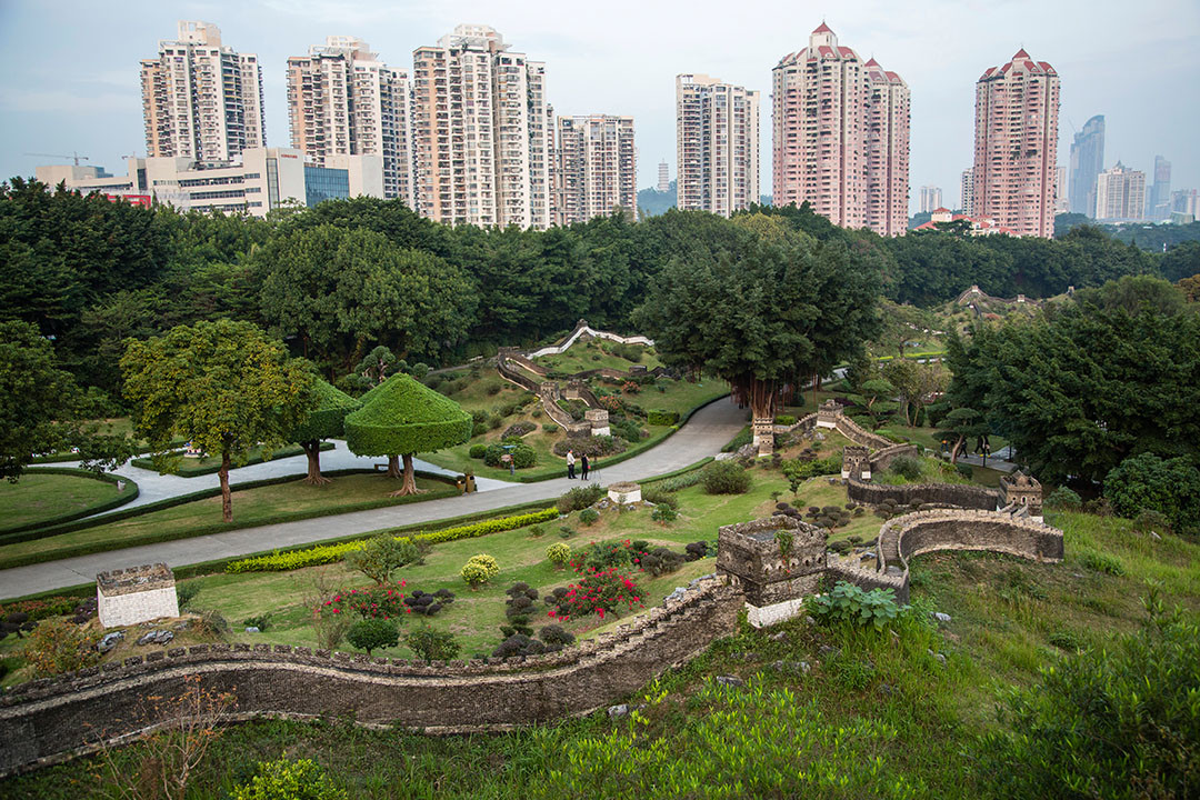 A mock Great Wall runs below megablock developments in the Splendid China theme park. - Shenzhen, China